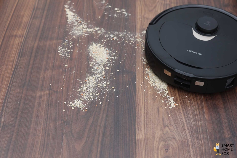 Der Roborock Q Revo reinigt Haferflocken beim Saugtest auf dem Laminat.